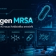 Illustration einer KI-gestützten Antibiotikaforschung: Eine Wissenschaftlerin analysiert am Computer neue Wirkstoffkandidaten gegen MRSA. Im Vordergrund sind Molekülstrukturen, Datenvisualisierungen und eine stilisierte Bakterienzelle zu sehen. Das Branding von tiny-tool.de sowie die Überschrift „KI gegen MRSA“ sind integriert.